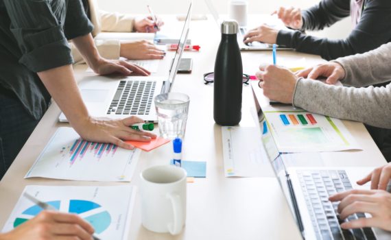 ידיים של מספר עובדים על השולחן